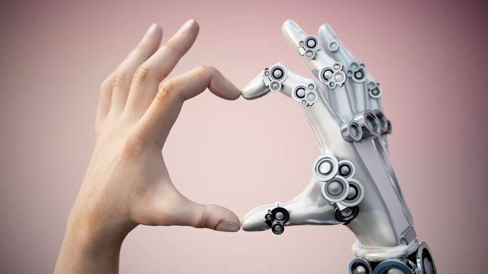 Eine menschliche Hand und eine Roboterhand formen gemeinsam ein Herz